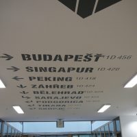 Názvy světových měst s orientačním značením na bílém stropě, malovaná grafika